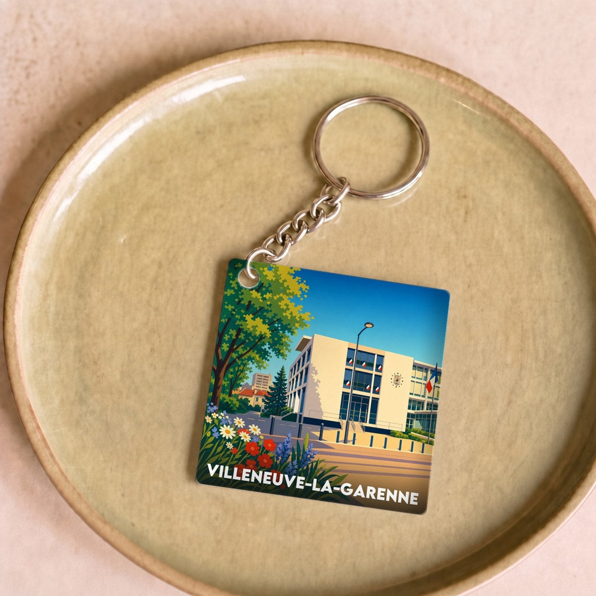 Porte-clés souvenir de la ville de Villeneuve-la-Garenne avec une illustration stylisée.