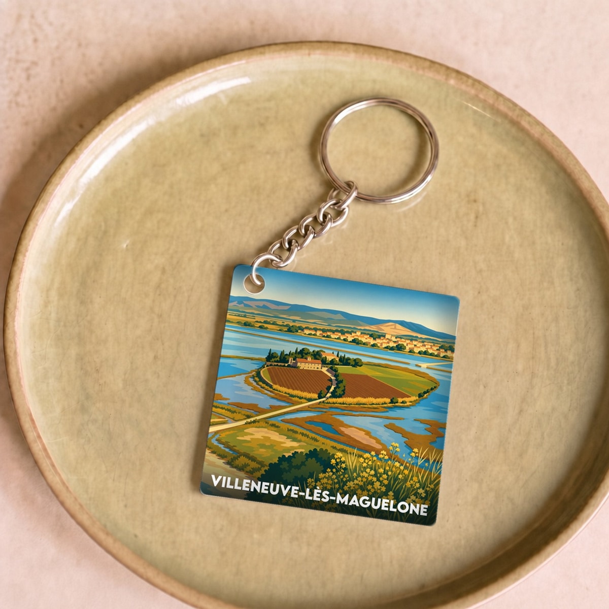 Porte-clés souvenir de la ville de Villeneuve-lès-Maguelone avec une illustration stylisée.