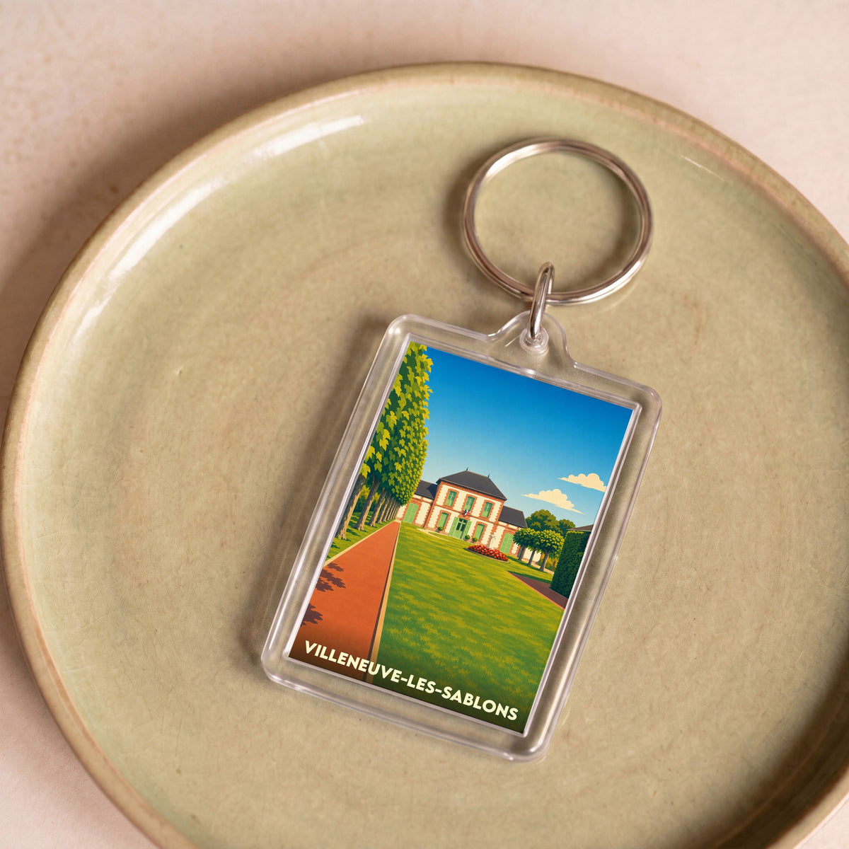 Porte-clés souvenir de la ville de Villeneuve-les-Sablons avec une illustration stylisée de sa mairie.