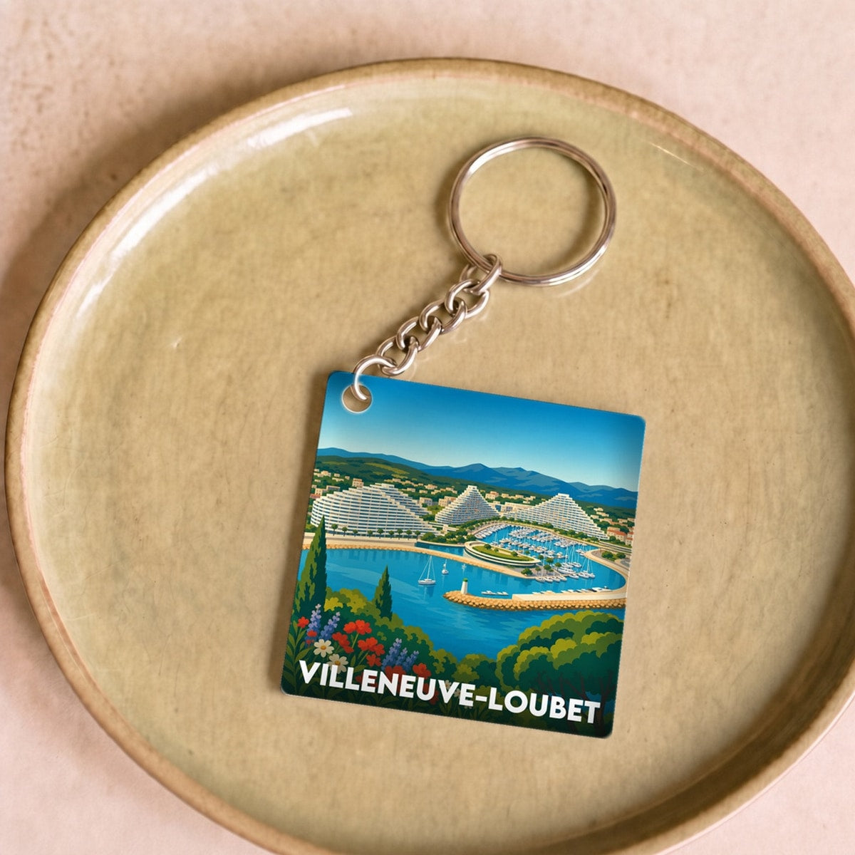 Porte-clés souvenir de la ville de Villeneuve-Loubet avec une illustration stylisée de sa marina.