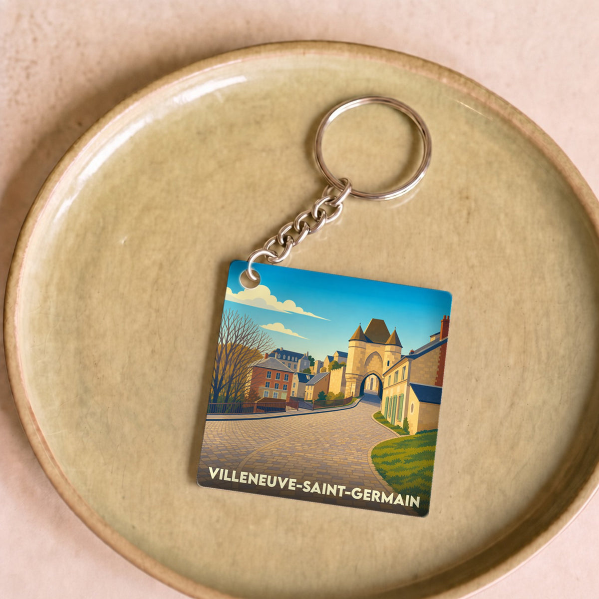 Porte-clés souvenir de la ville de Villeneuve-Saint-Germain avec une illustration stylisée de ses bâtiments historiques.