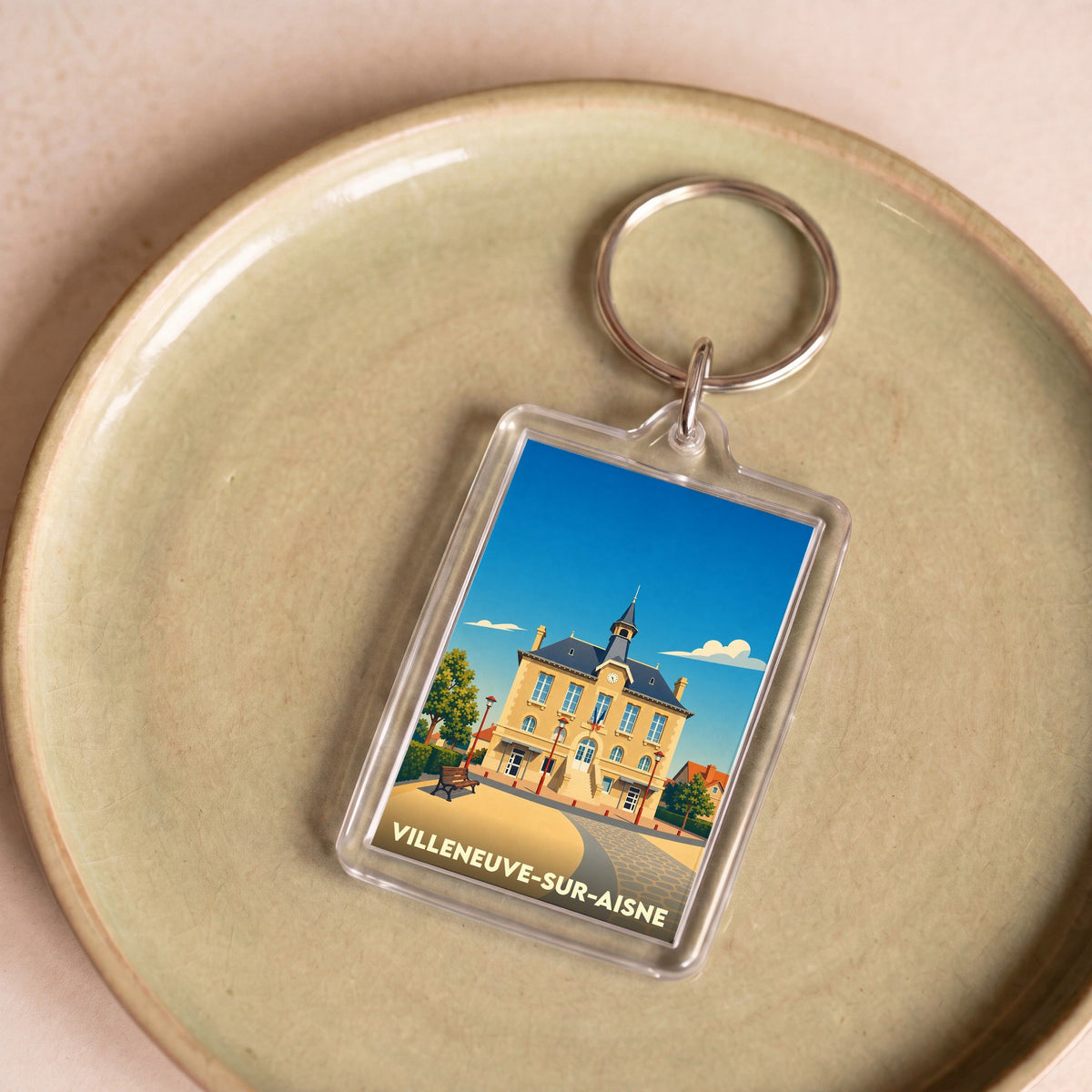 Porte-clés souvenir de la ville de Villeneuve-sur-Aisne avec une illustration stylisée de son hôtel de ville.