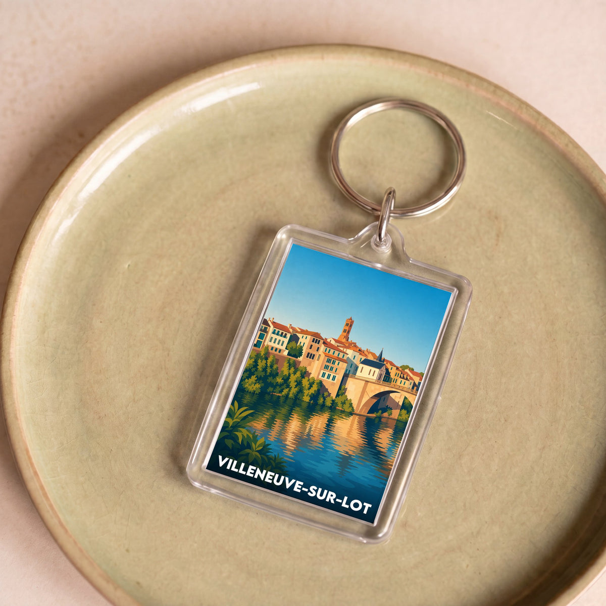 Porte-clés souvenir de la ville de Villeneuve-sur-Lot avec une illustration stylisée.
