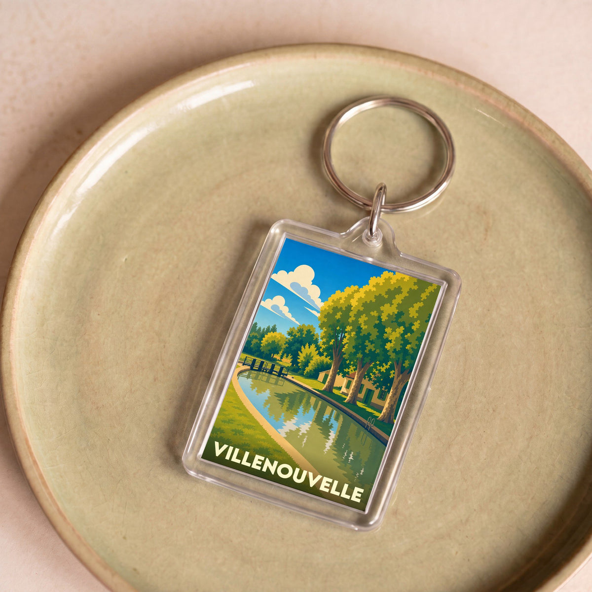 Porte-clés souvenir de la ville de Villenouvelle avec une illustration stylisée.