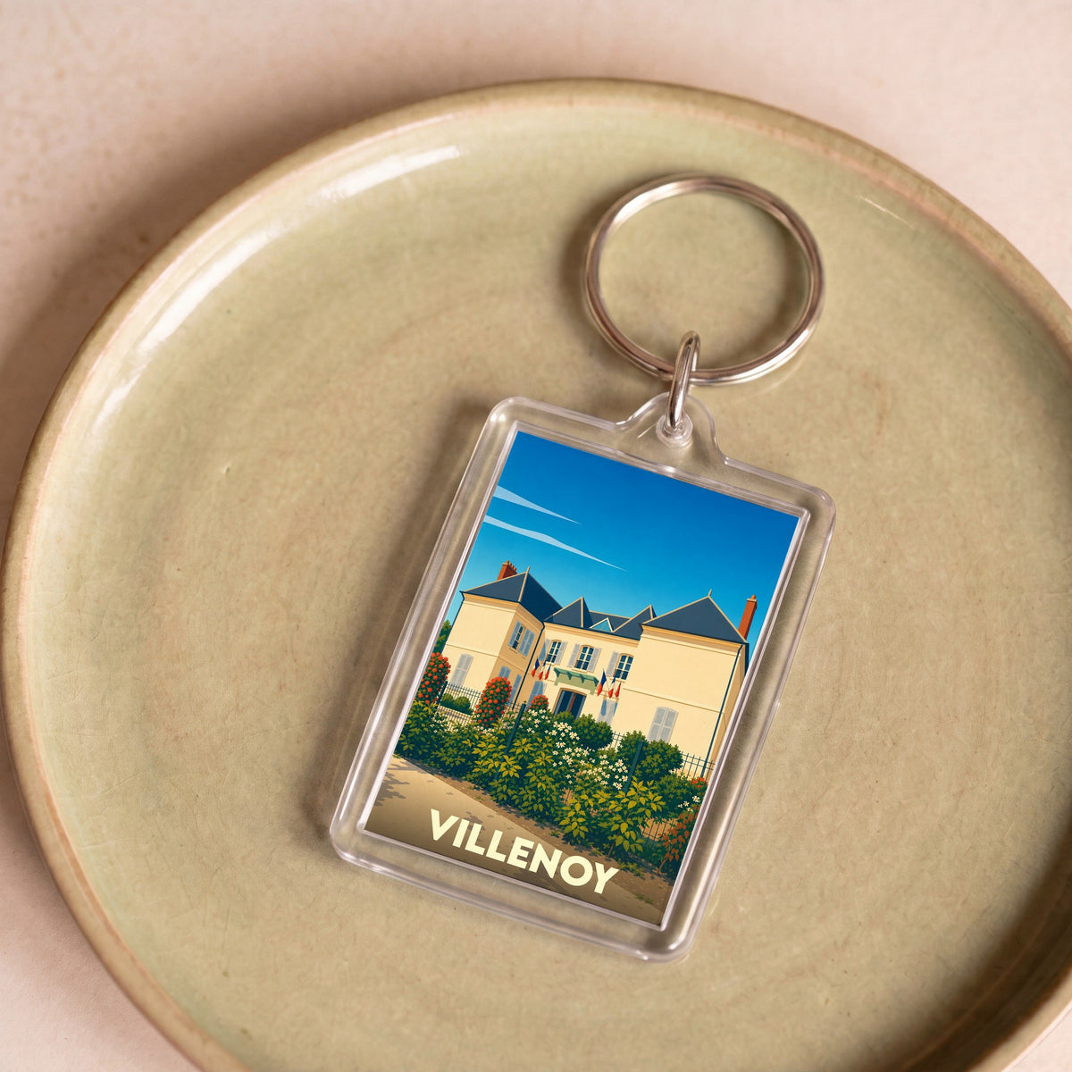 Porte-clés souvenir de la ville de Villenoy avec une illustration stylisée de la mairie.