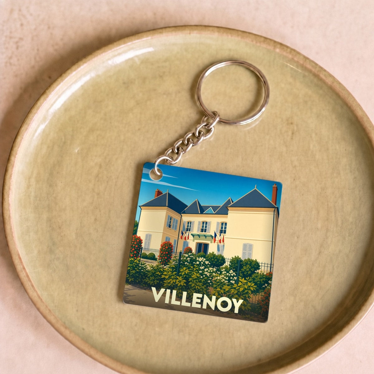 Porte-clés souvenir de la ville de Villenoy avec une illustration stylisée de la mairie.