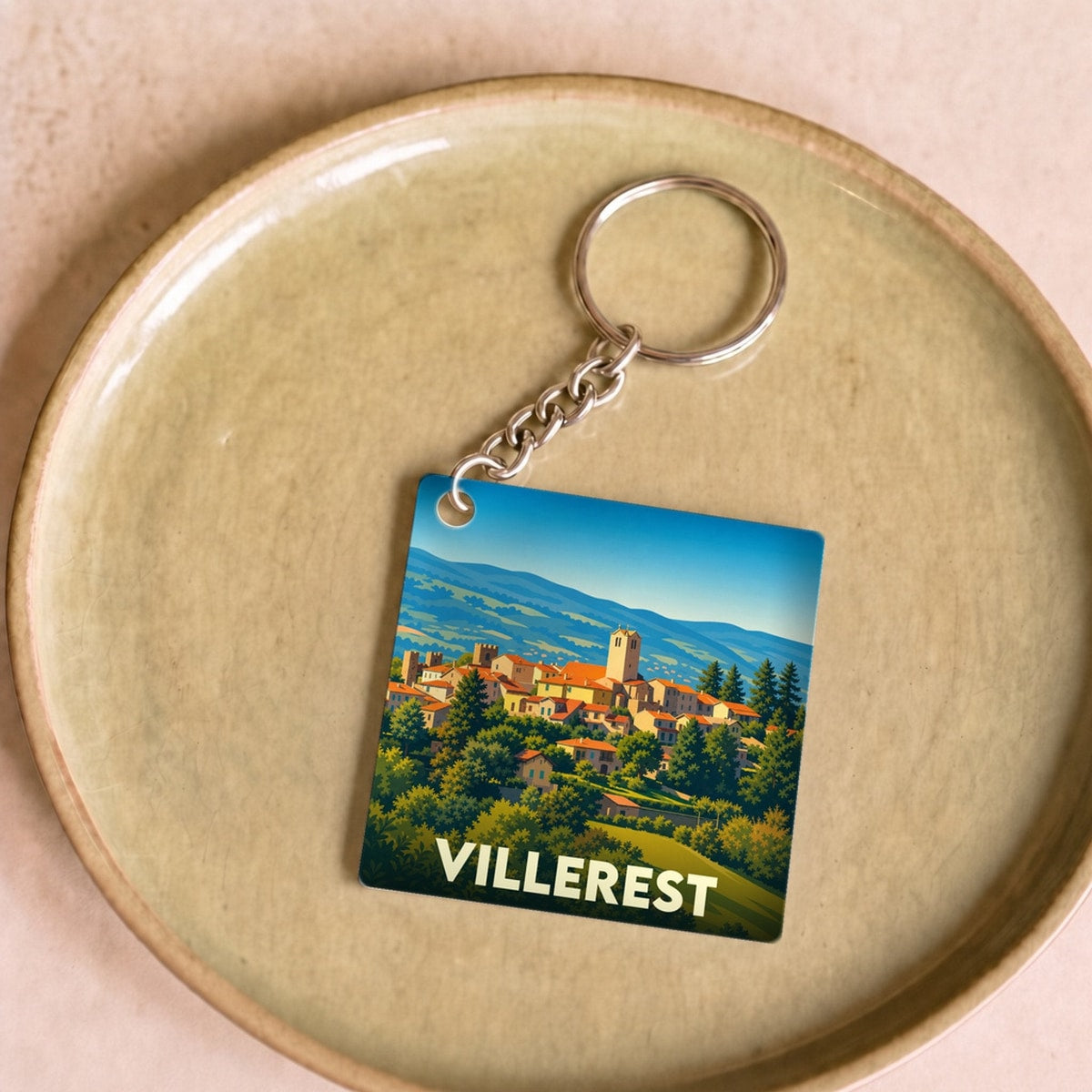 Porte-clés souvenir de la ville de Villerest avec une illustration stylisée d'un village perché.