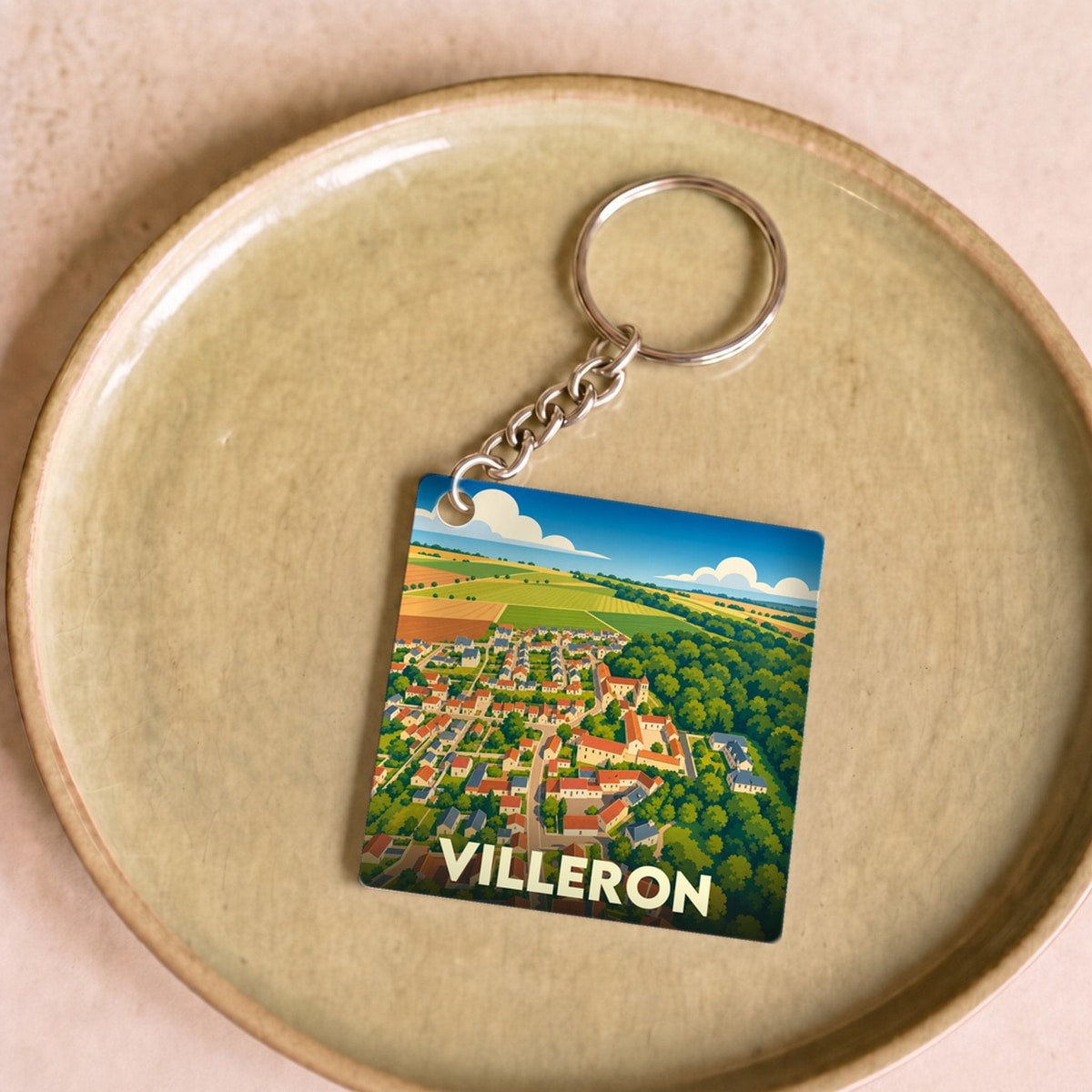 Porte-clés souvenir de la ville de Villeron avec une illustration stylisée vue du ciel.