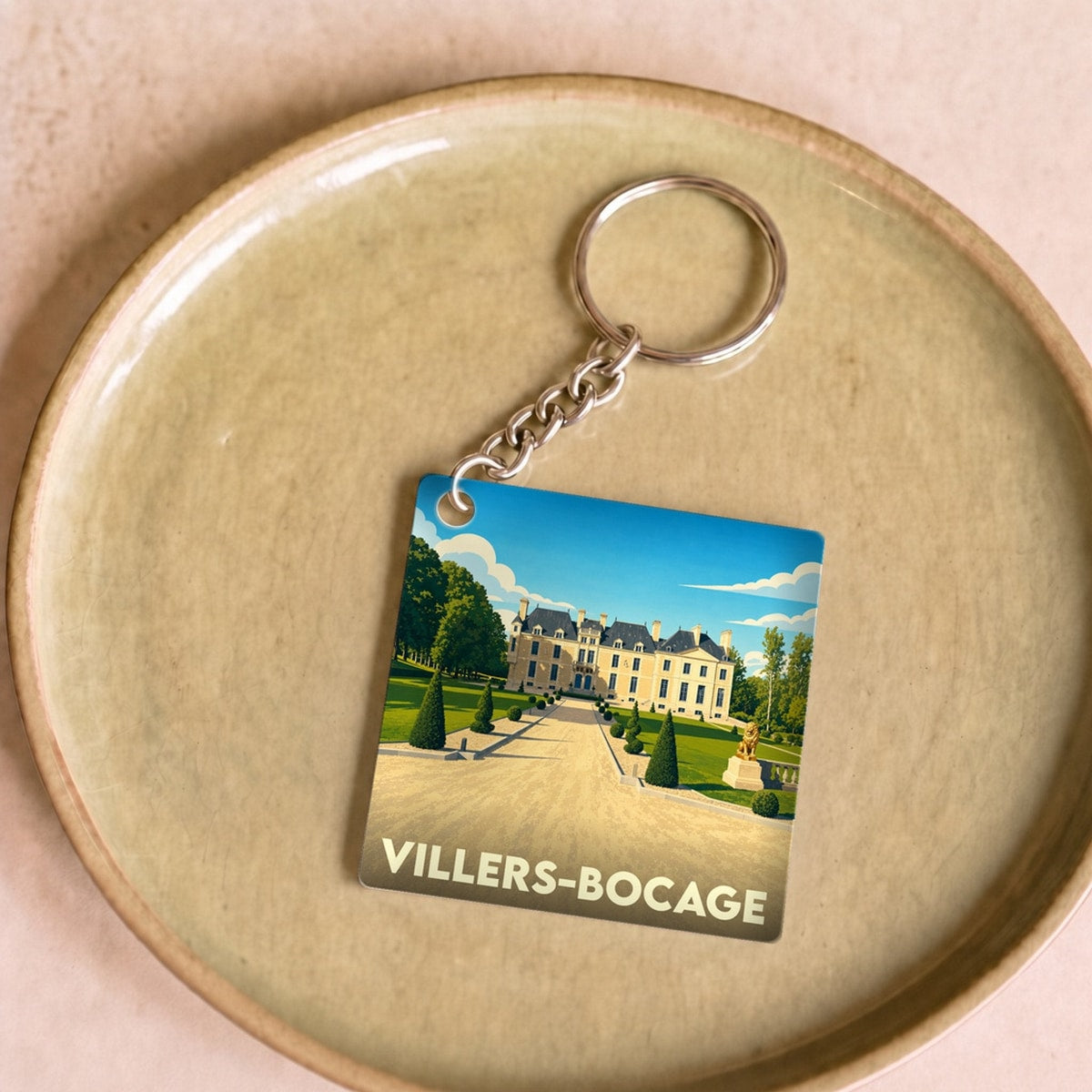 Porte-clés souvenir de la ville de Villers-Bocage avec une illustration stylisée d'un château.