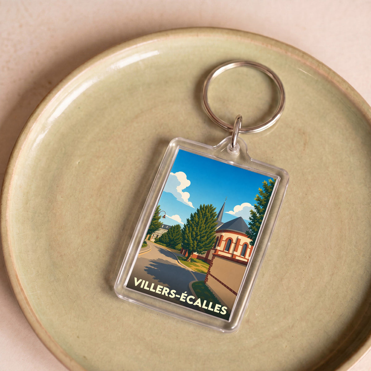 Porte-clés souvenir de la ville de Villers-Écalles avec une illustration stylisée.