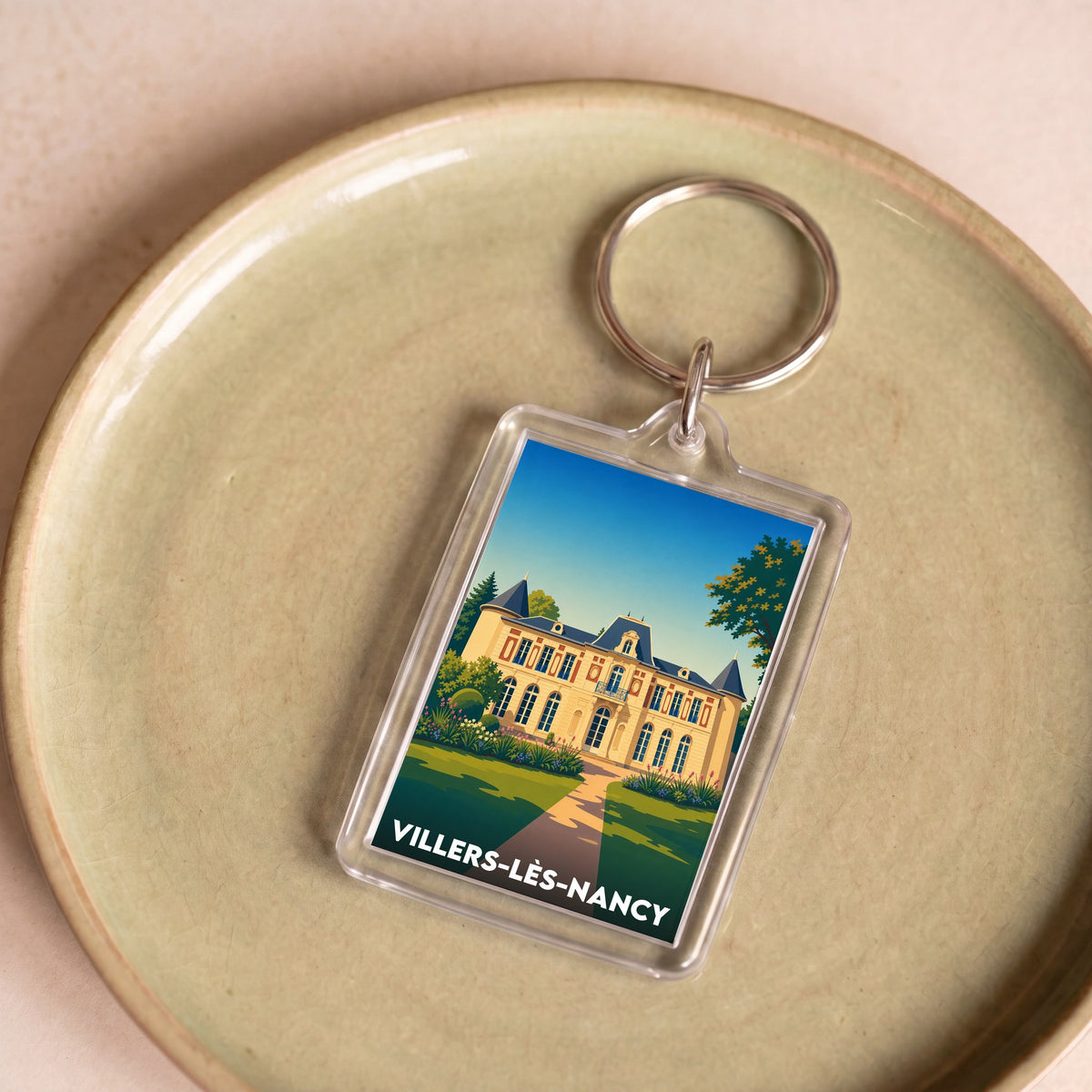 Porte-clés souvenir de la ville de Villers-lès-Nancy avec une illustration stylisée.