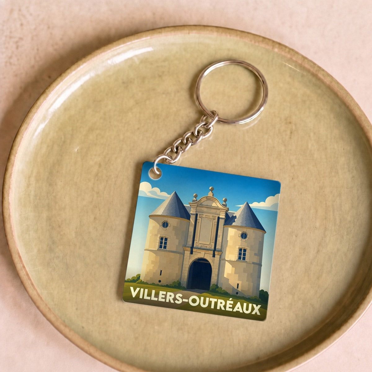 Porte-clés souvenir de la ville de Villers-Outréaux avec une illustration stylisée de son château.