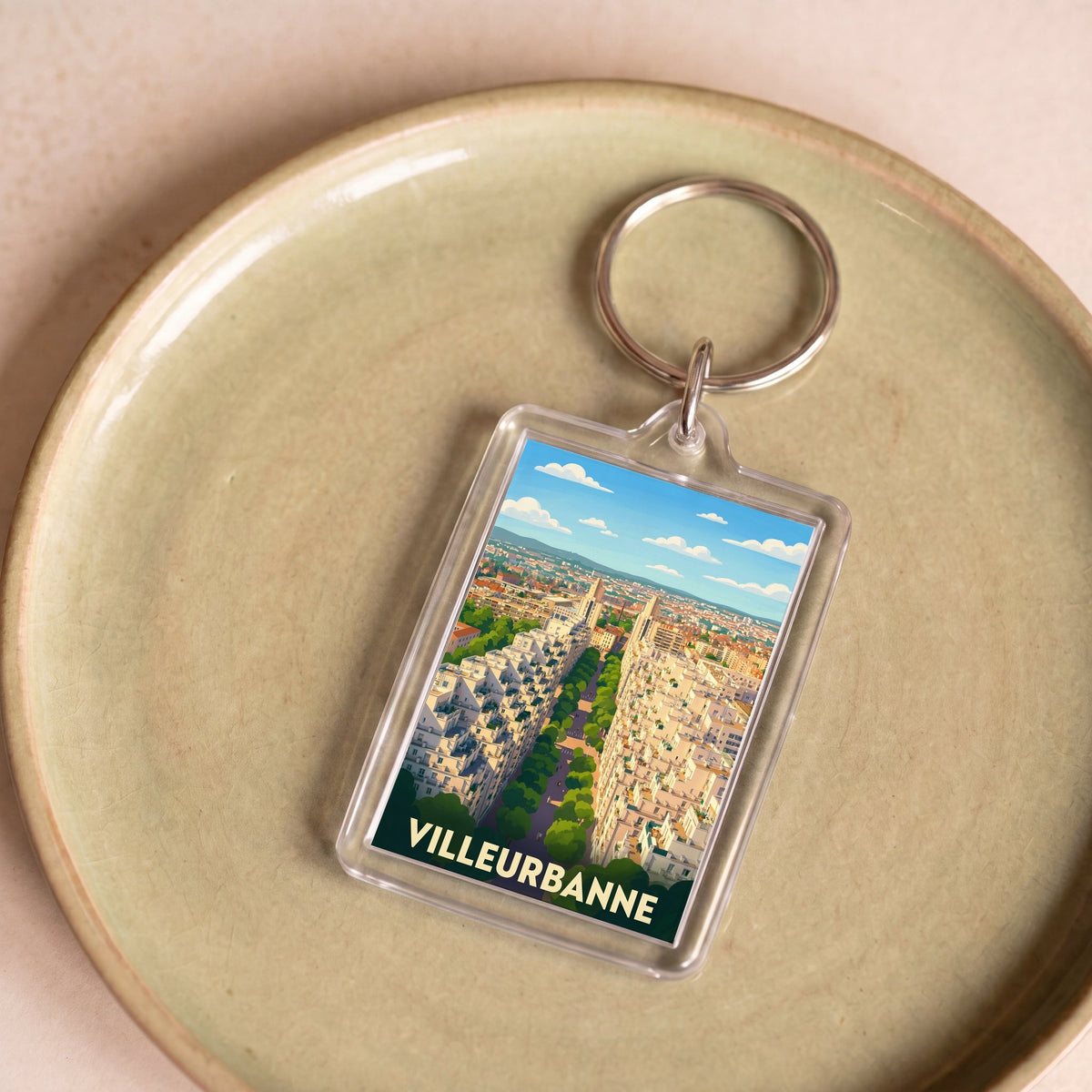 Porte-clés souvenir de la ville de Villeurbanne avec une illustration stylisée.