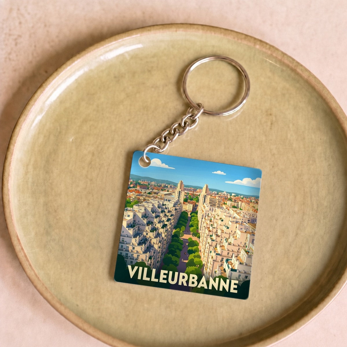 Porte-clés souvenir de la ville de Villeurbanne avec une illustration stylisée.