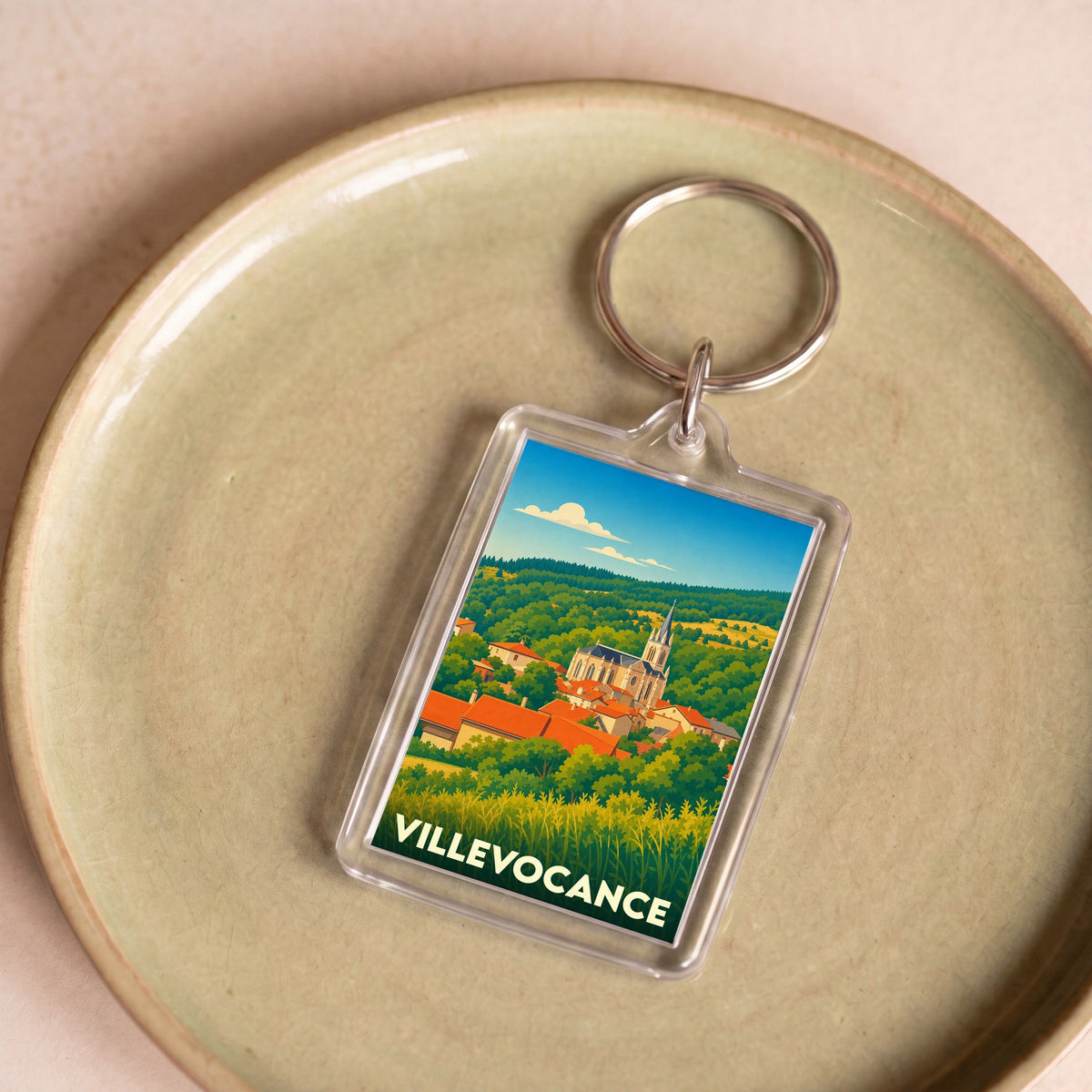 Porte-clés souvenir de la ville de Villevocance avec une illustration stylisée du village.