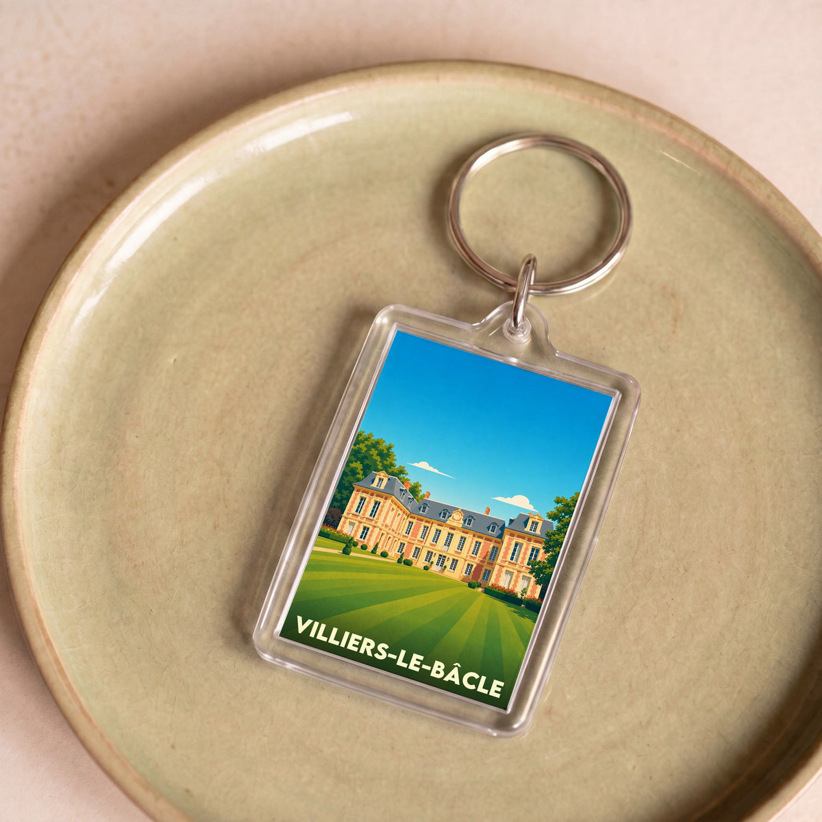 Porte-clés souvenir de la ville de Villiers-le-Bâcle avec une illustration stylisée de son château.