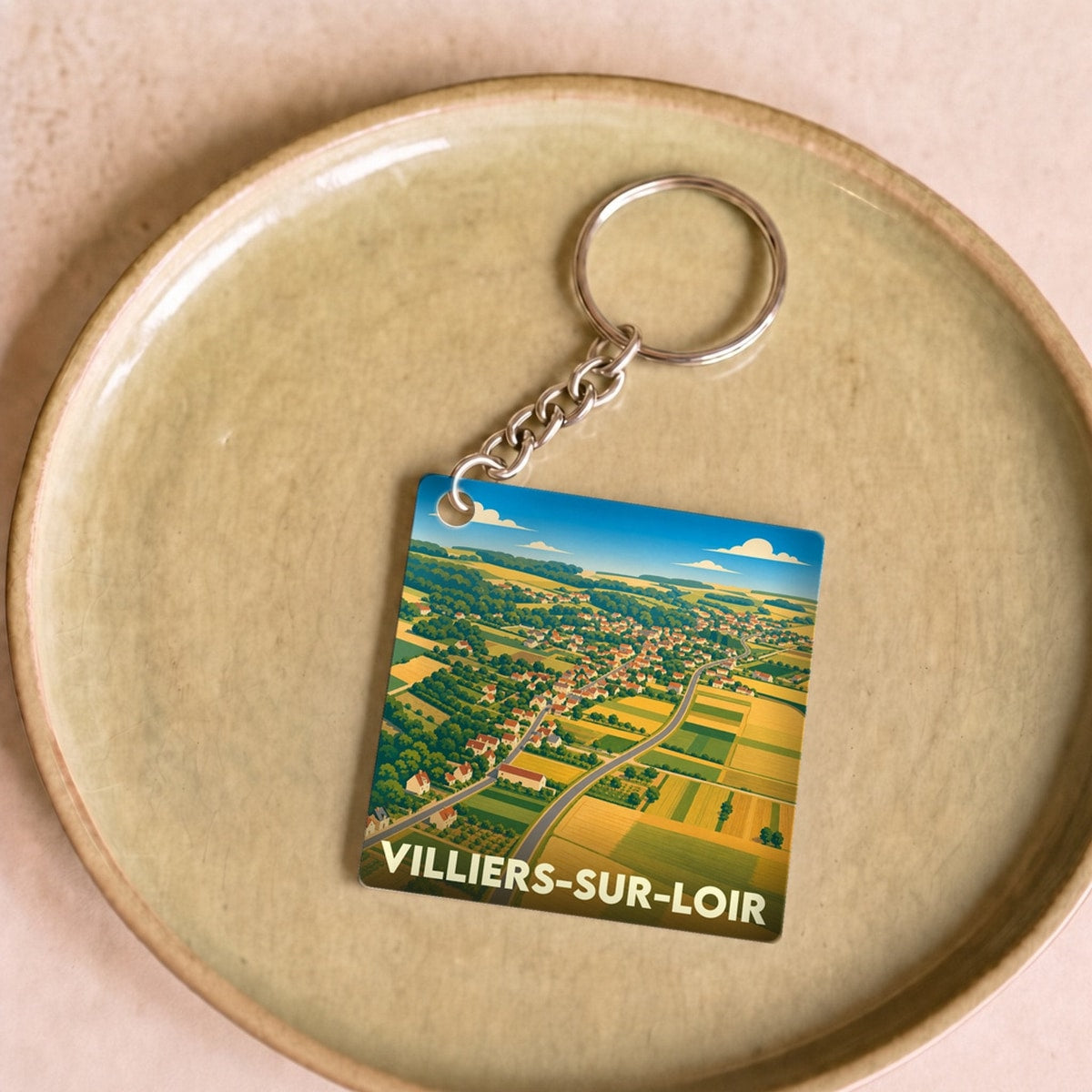 Porte-clés souvenir de la ville de Villiers-sur-Loir avec une illustration stylisée de ses paysages.