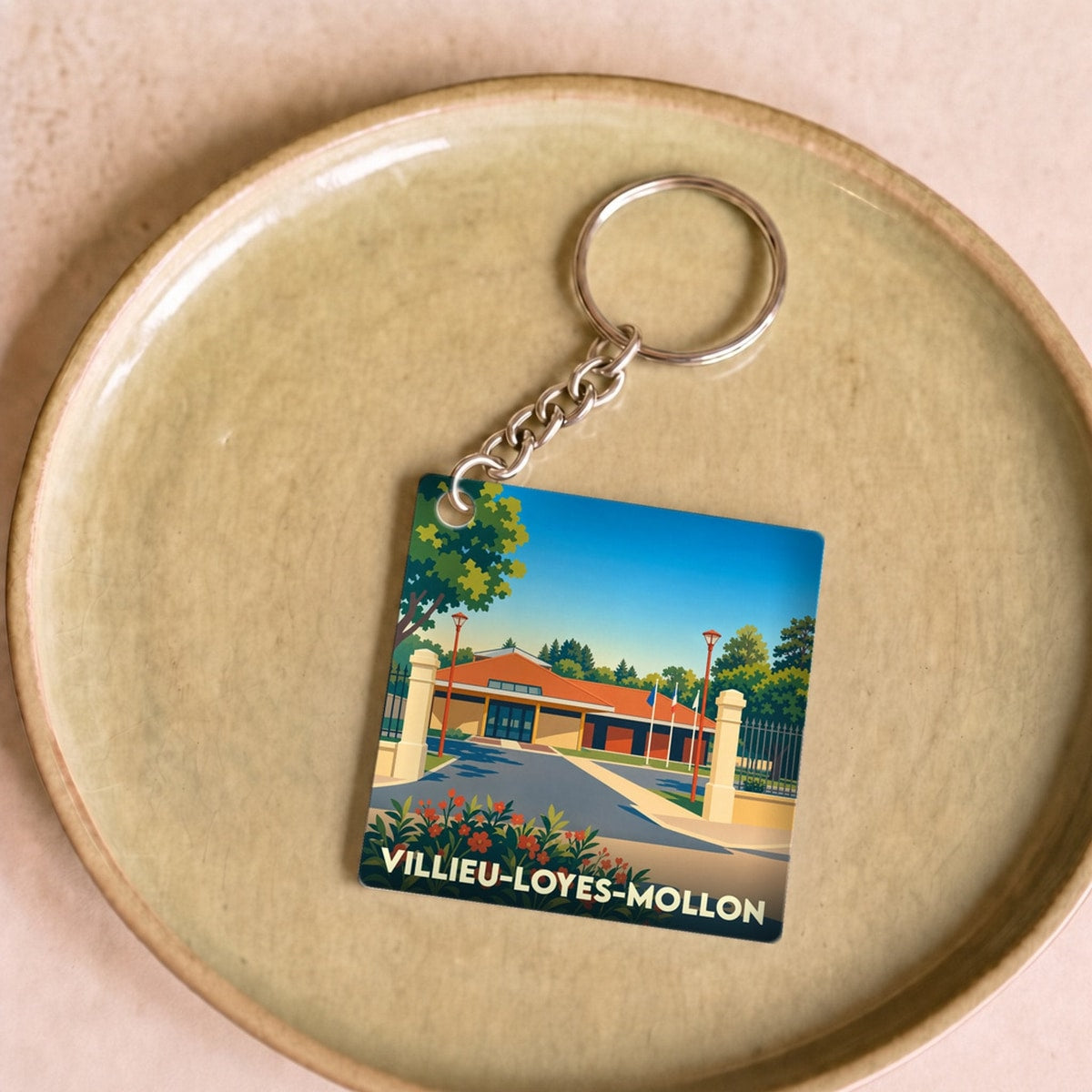 Porte-clés souvenir de la ville de Villieu-Loyes-Mollon avec une illustration stylisée.