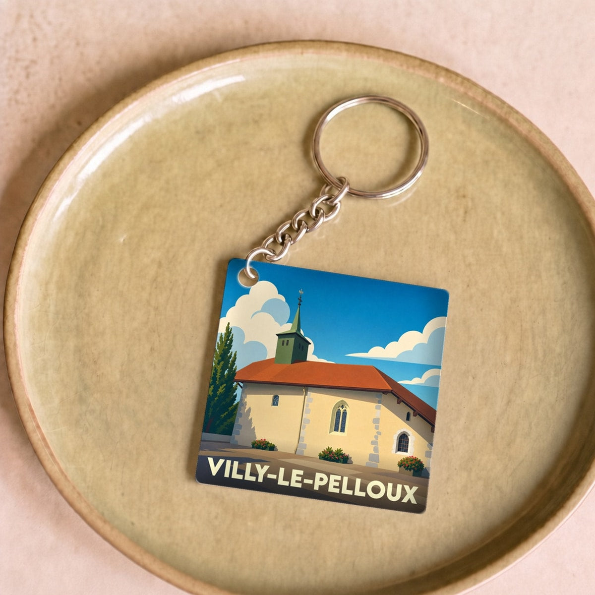 Porte-clés souvenir de la ville de Villy-le-Pelloux avec une illustration stylisée de son église.