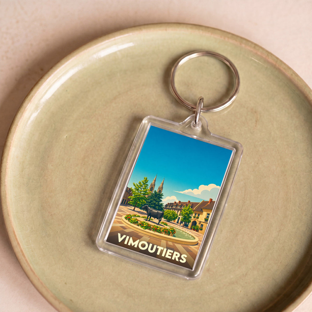 Porte-clés souvenir de la ville de Vimoutiers avec une illustration stylisée.