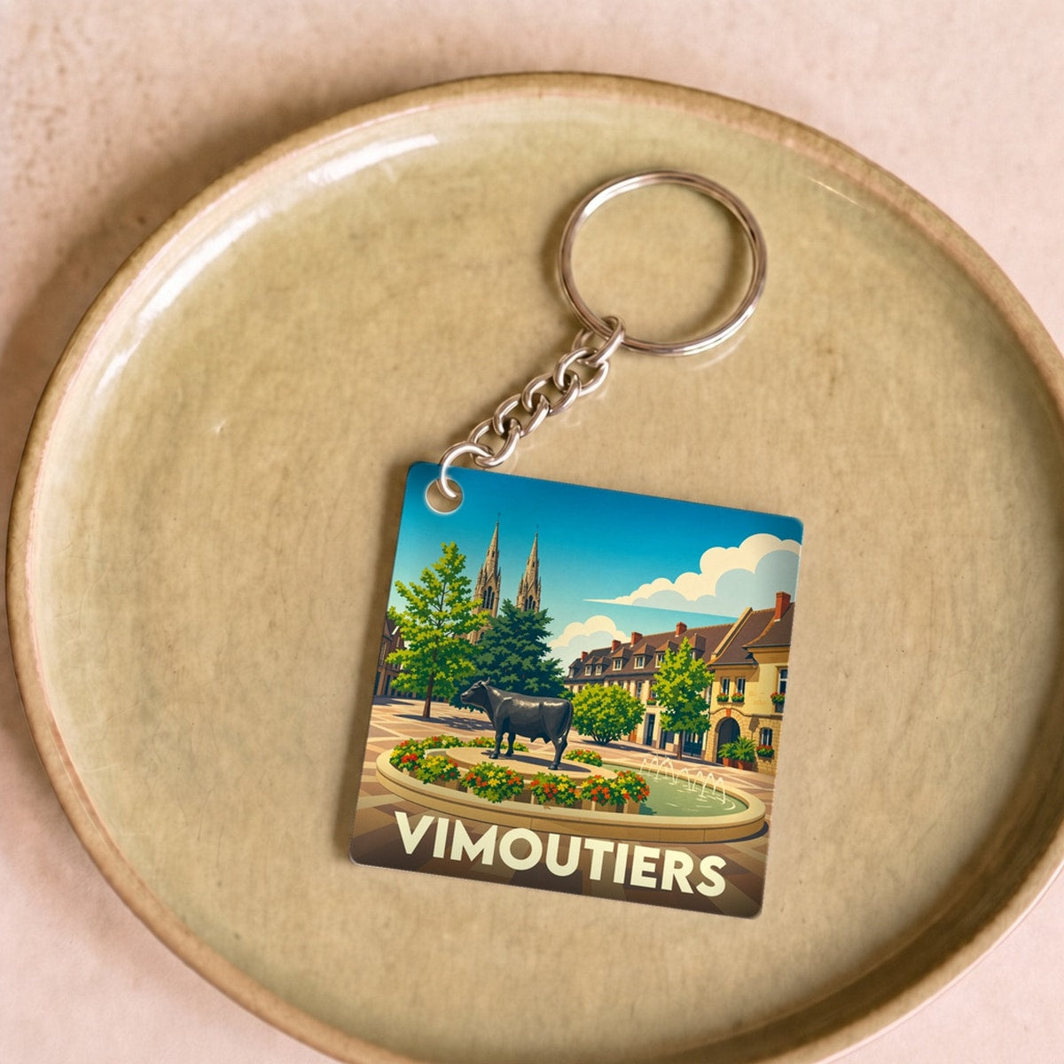 Porte-clés souvenir de la ville de Vimoutiers avec une illustration stylisée.