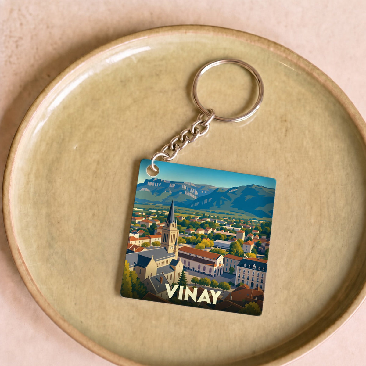 Porte-clés souvenir de la ville de Vinay avec une illustration stylisée.