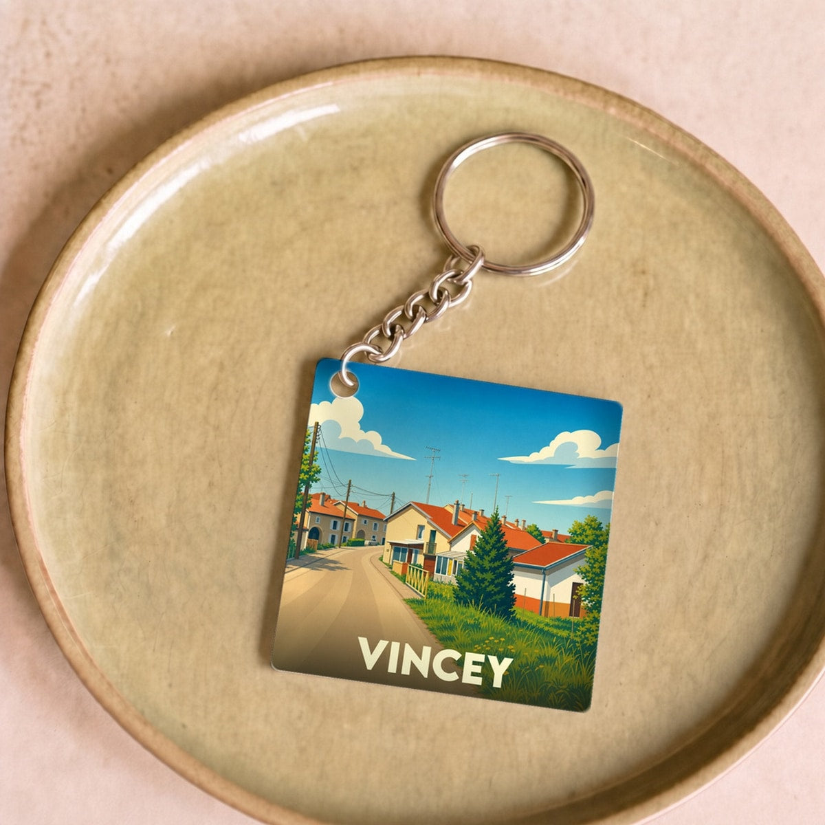Porte-clés souvenir de la ville de Vincey avec une illustration stylisée.