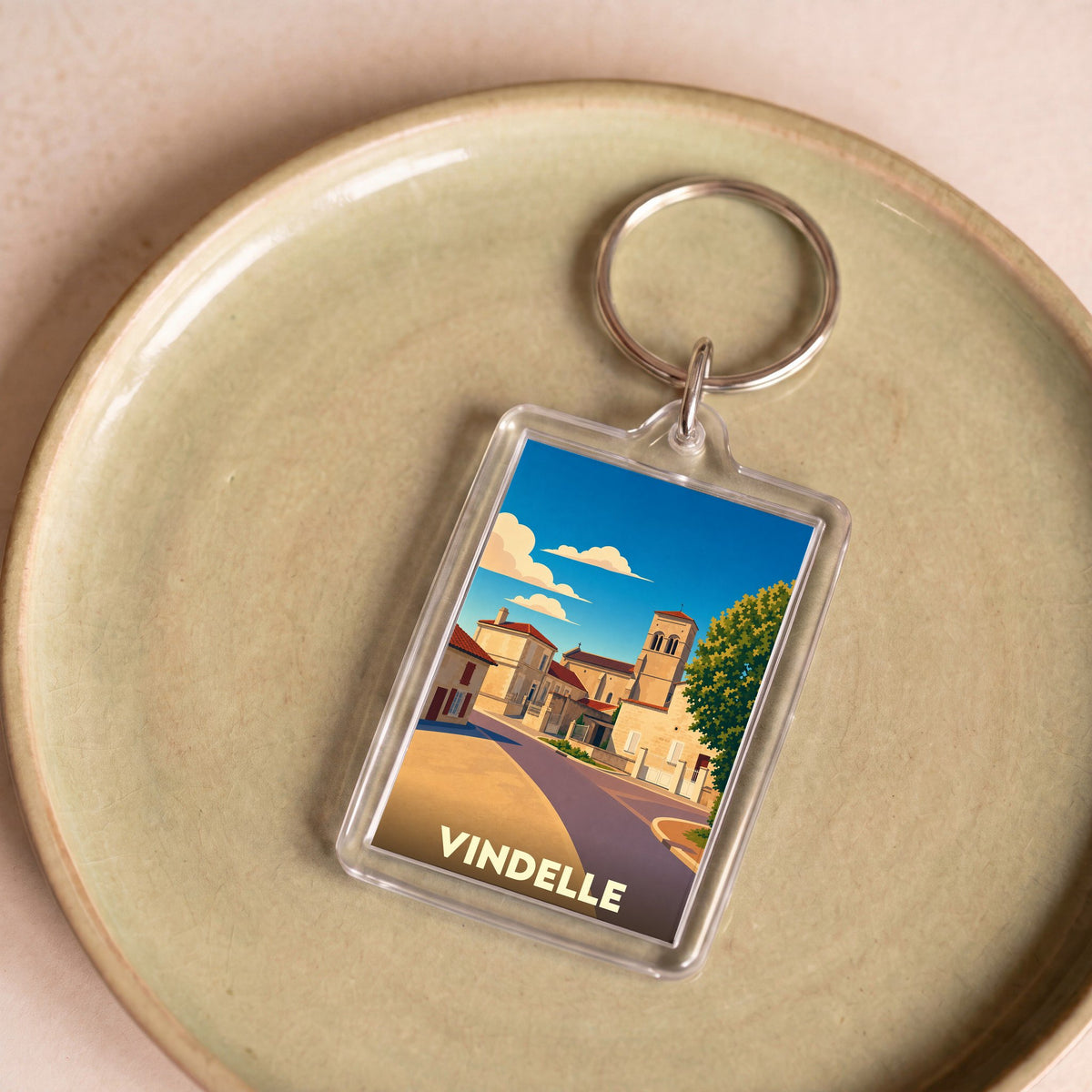 Porte-clés souvenir de la ville de Vindelle avec une illustration stylisée.