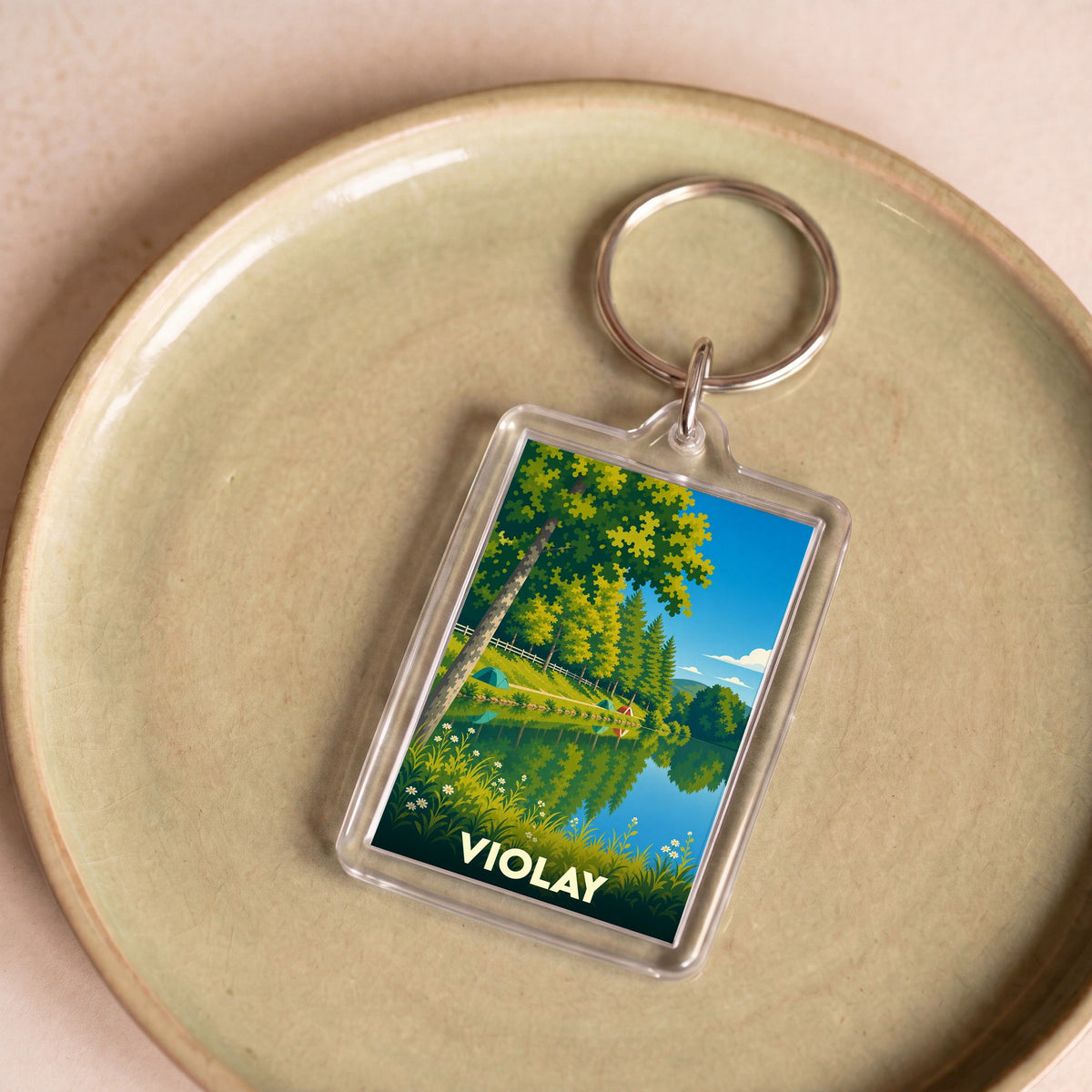 Porte-clés souvenir de la ville de Violay avec une illustration stylisée de paysage lacustre.