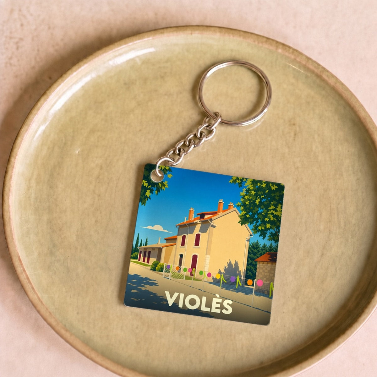 Porte-clés souvenir de la ville de Violès avec une illustration stylisée.