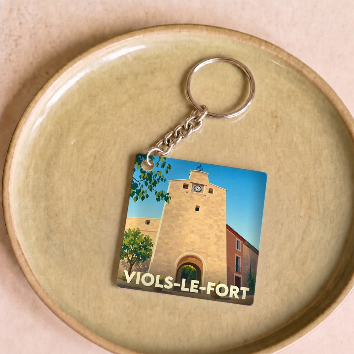 Porte-clés souvenir de la ville de Viols-le-Fort avec une illustration stylisée.