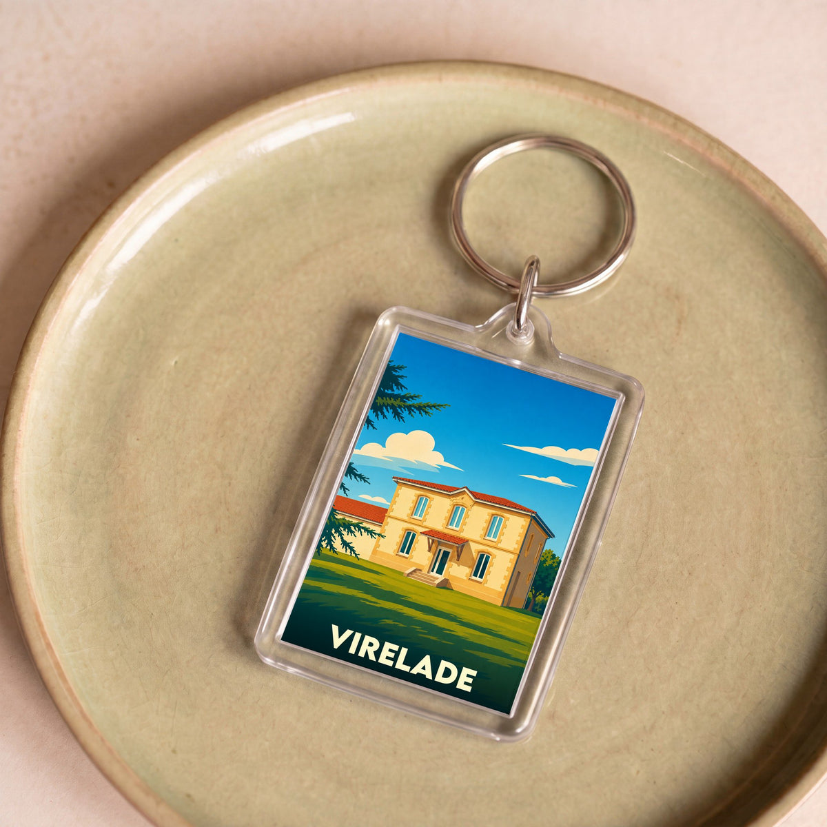 Porte-clés souvenir de la ville de Virelade avec une illustration stylisée d'une maison de maître.