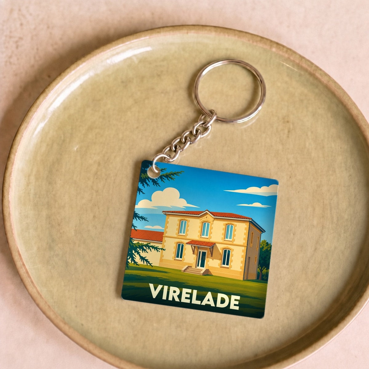 Porte-clés souvenir de la ville de Virelade avec une illustration stylisée d'une maison de maître.