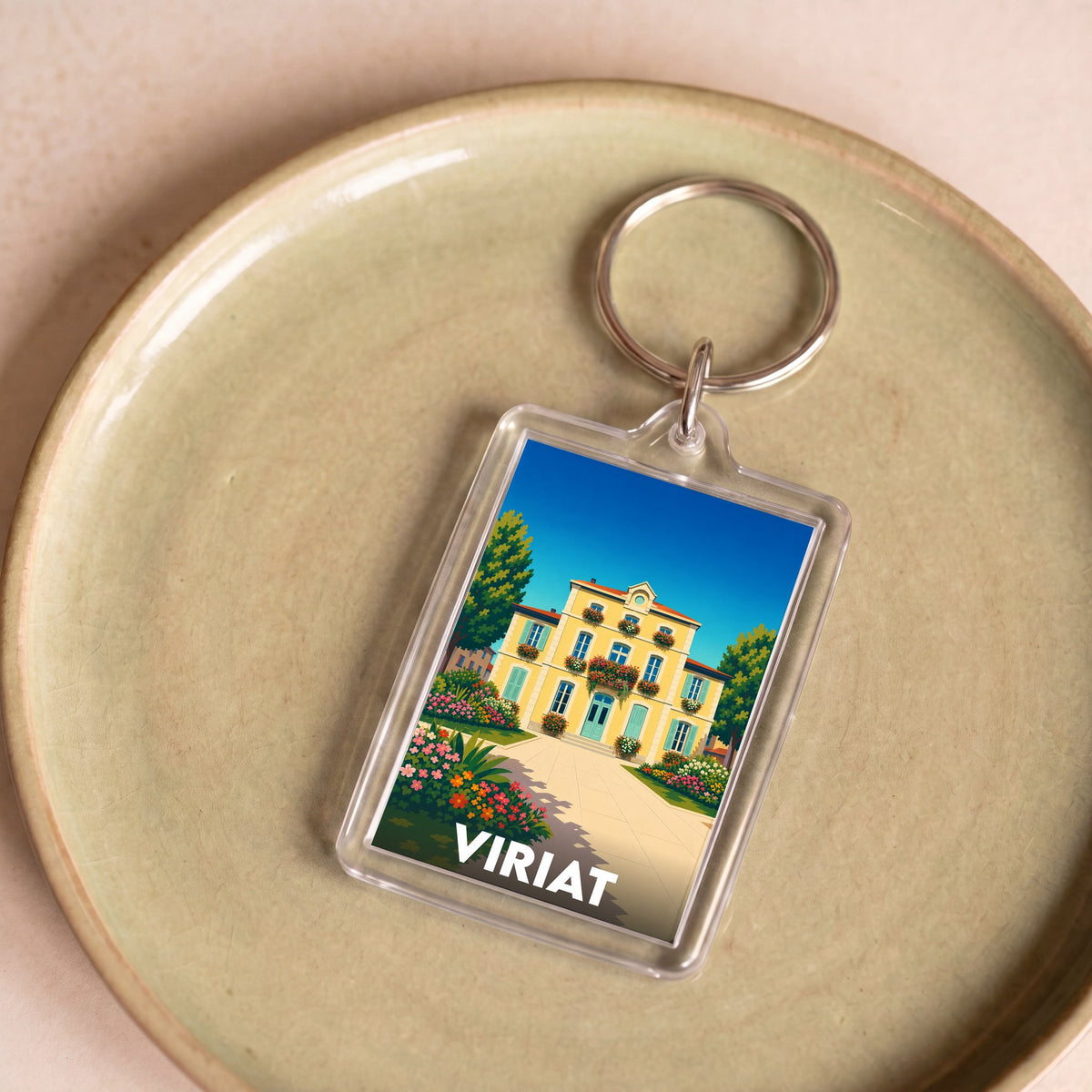 Porte-clés souvenir de la ville de Viriat avec une illustration stylisée d'une maison fleurie.