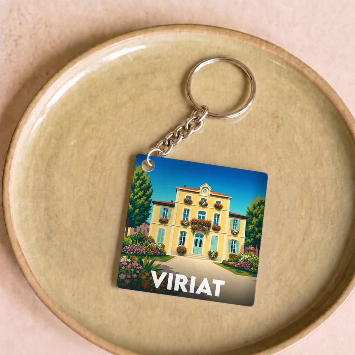Porte-clés souvenir de la ville de Viriat avec une illustration stylisée d'une maison fleurie.