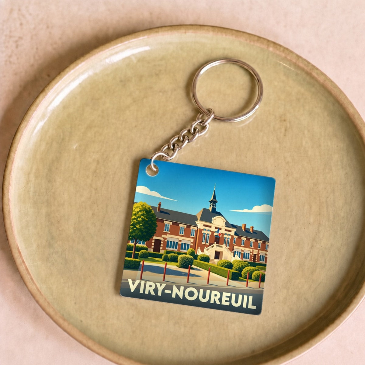 Porte-clés souvenir de la ville de Viry-Noureuil avec une illustration stylisée de sa mairie.