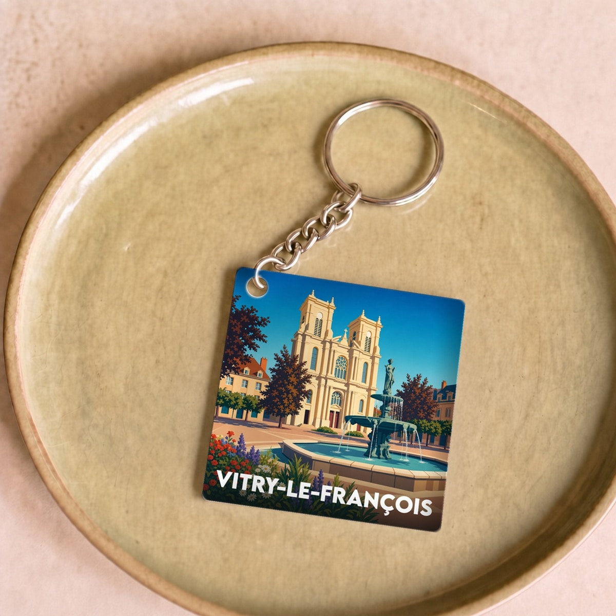Porte-clés souvenir de la ville de Vitry-le-François avec une illustration stylisée.