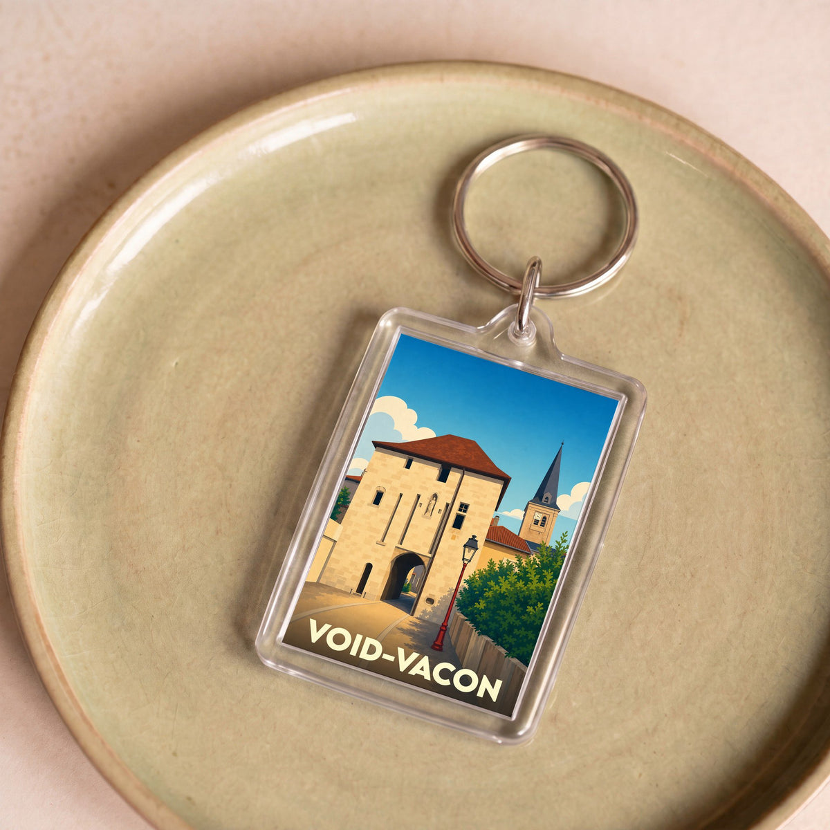 Porte-clés souvenir de la ville de Void-Vacon avec une illustration stylisée d'une porte médiévale.