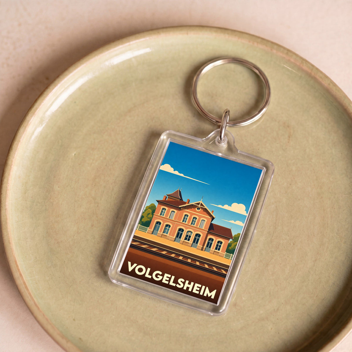 Porte-clés souvenir de la ville de Volgelsheim avec une illustration stylisée de sa gare.