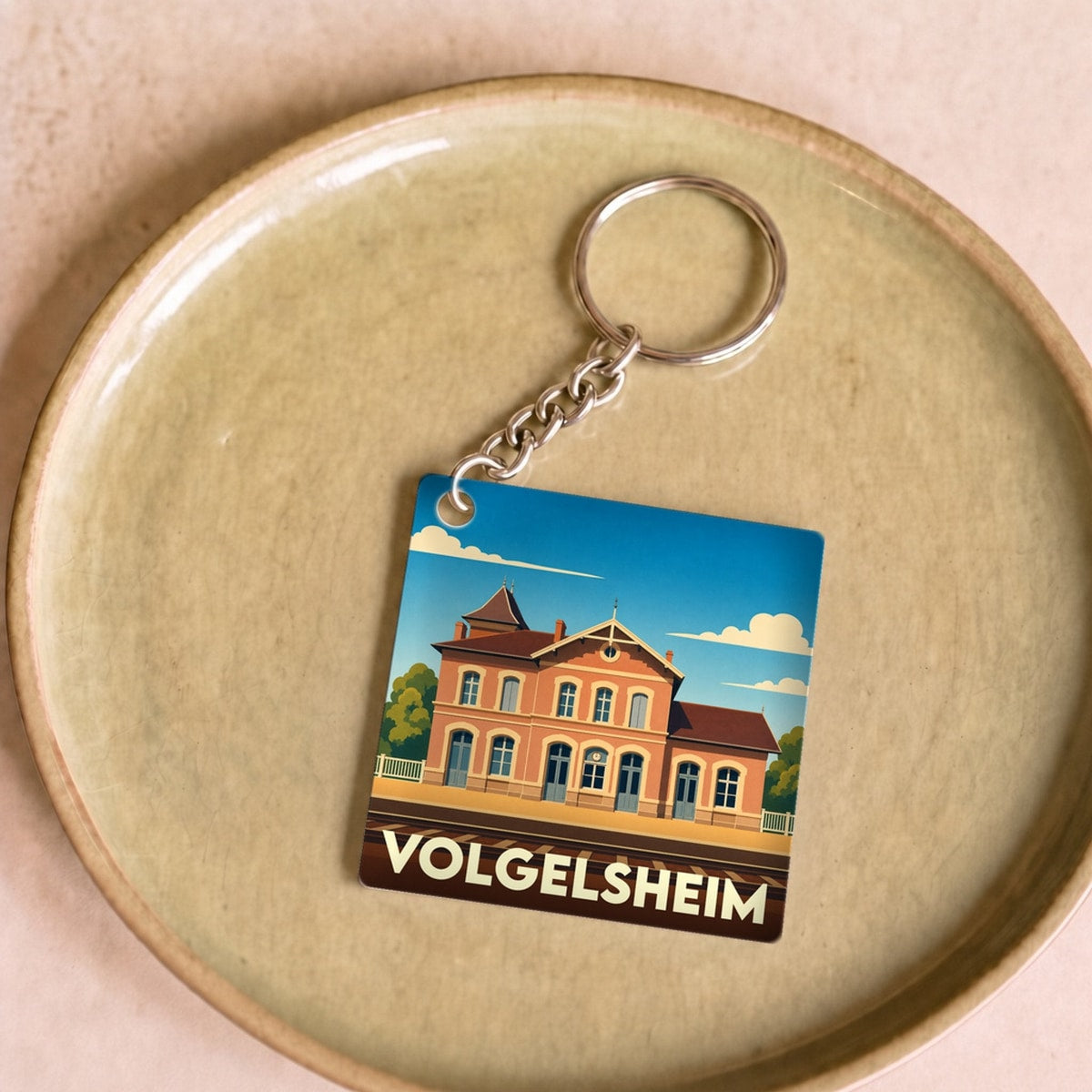 Porte-clés souvenir de la ville de Volgelsheim avec une illustration stylisée de sa gare.