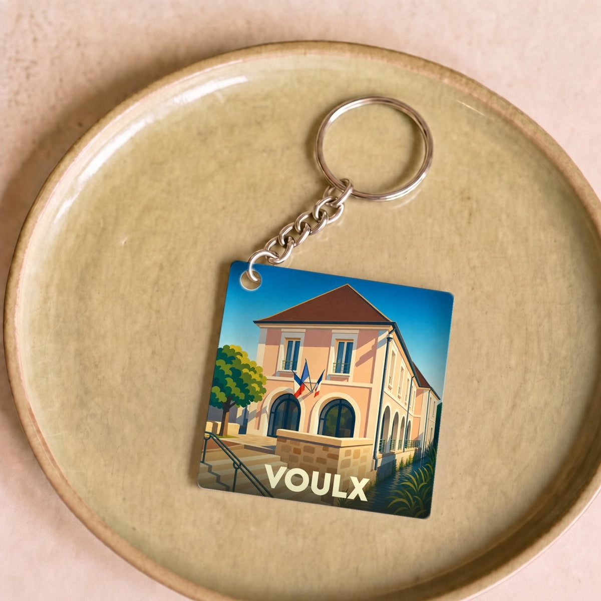 Porte-clés souvenir de la ville de Voulx avec une illustration stylisée de sa mairie.