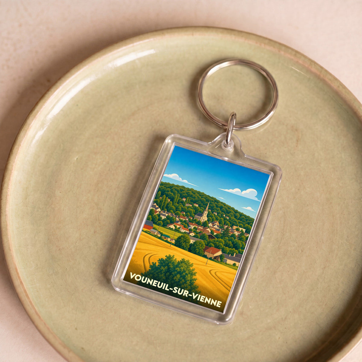 Porte-clés souvenir de la ville de Vouneuil-sur-Vienne avec une illustration stylisée.