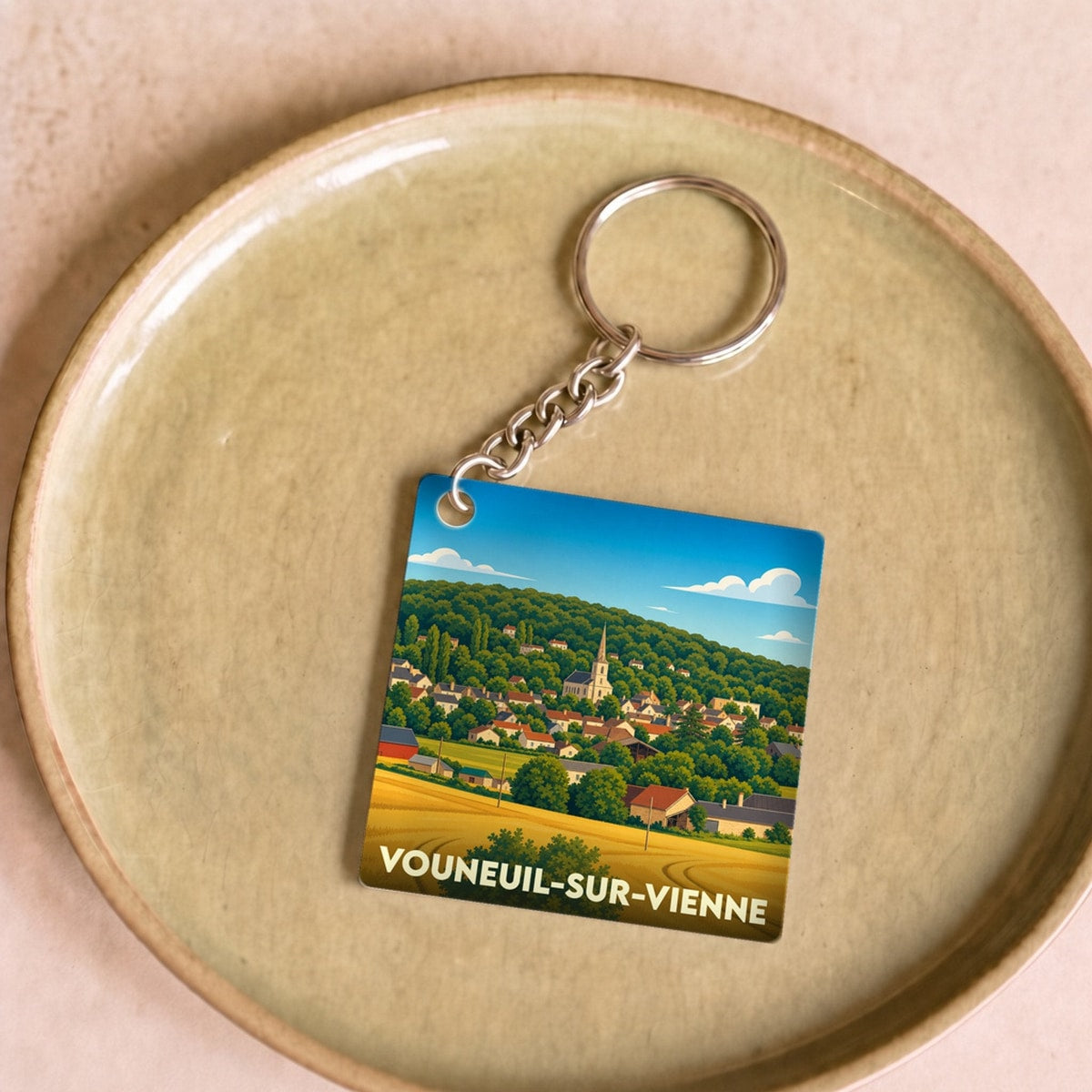 Porte-clés souvenir de la ville de Vouneuil-sur-Vienne avec une illustration stylisée.