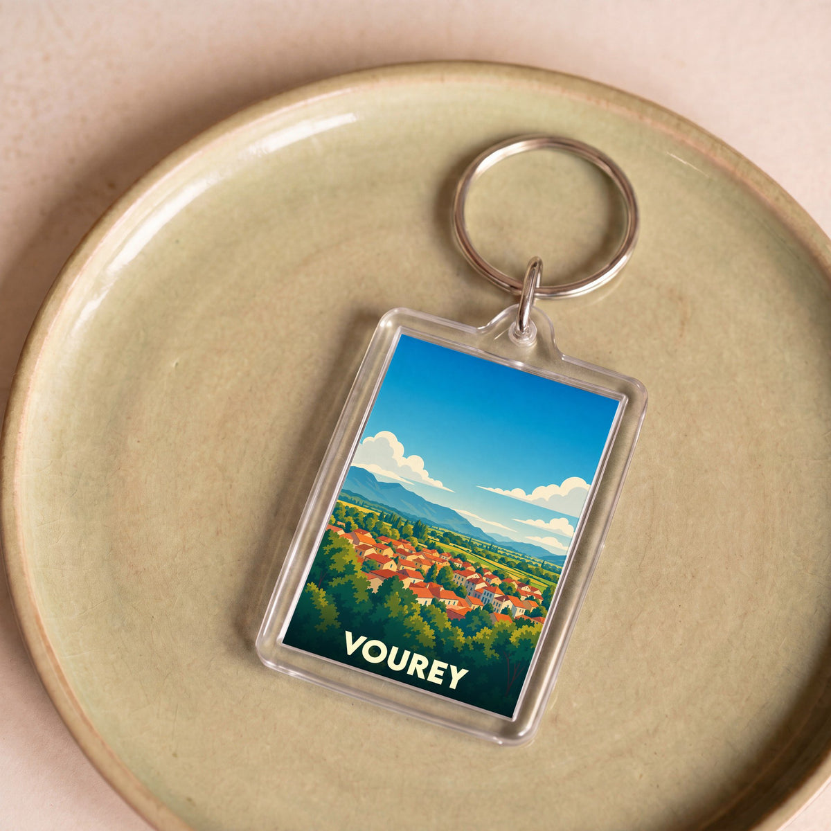 Porte-clés souvenir de la ville de Vourey avec une illustration stylisée de son paysage.