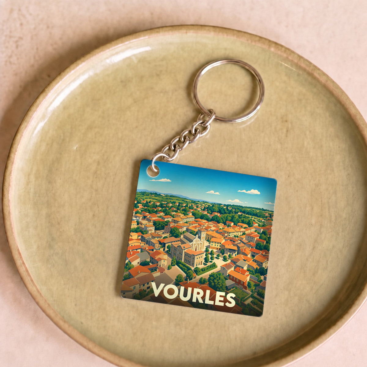 Porte-clés souvenir de la ville de Vourles avec une illustration stylisée.