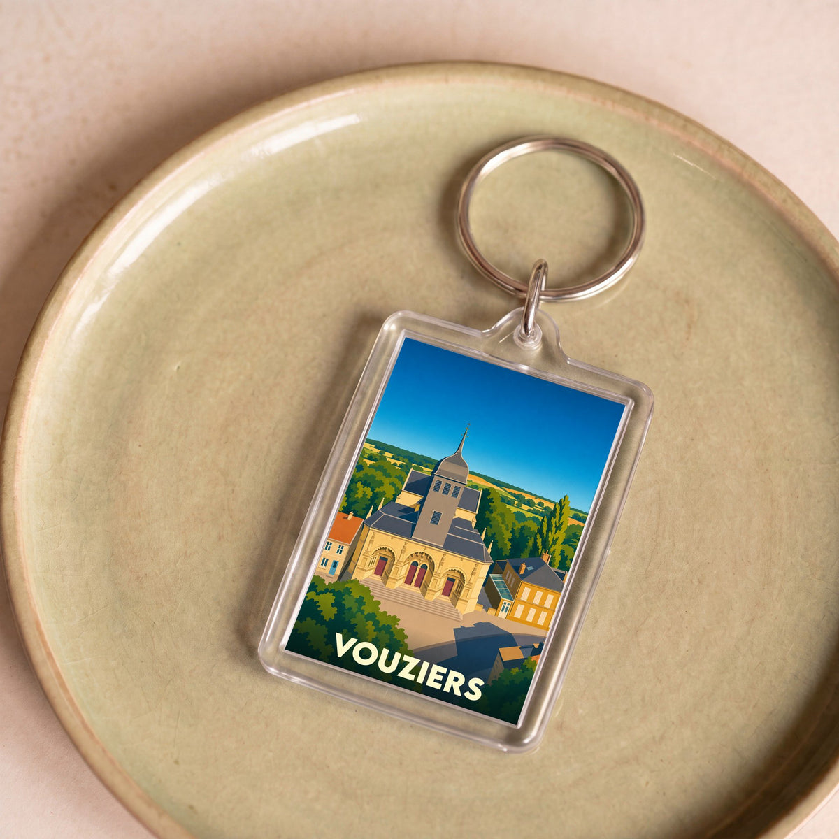Porte-clés souvenir de la ville de Vouziers avec une illustration stylisée de son église.