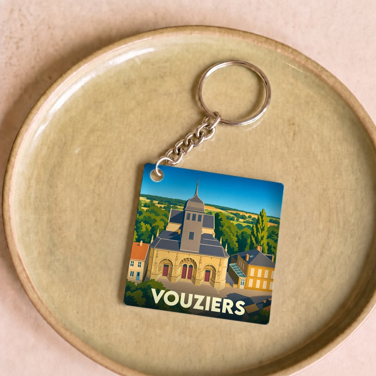 Porte-clés souvenir de la ville de Vouziers avec une illustration stylisée de son église.
