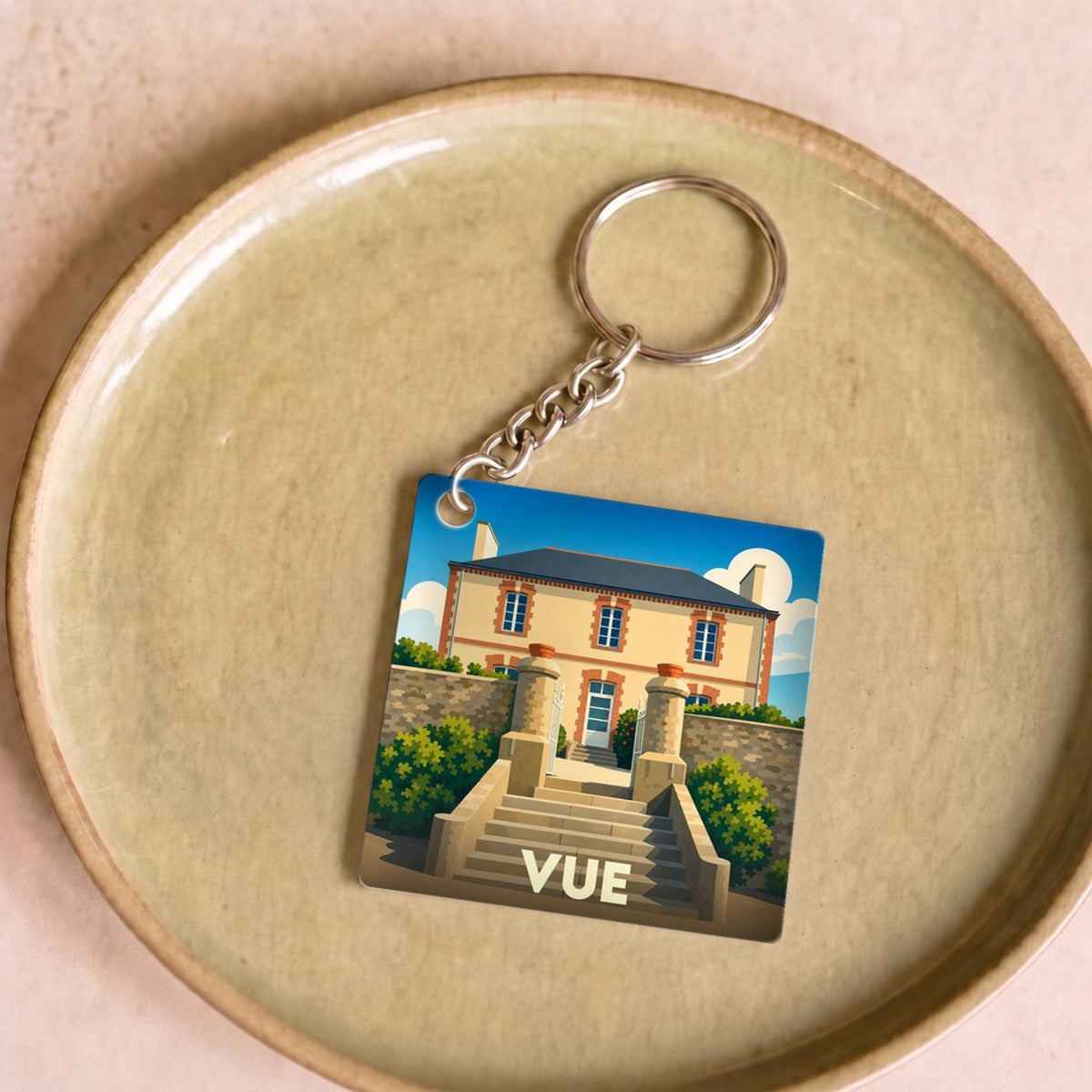 Porte-clés souvenir de la ville de Vue avec une illustration stylisée d'une maison de maître.