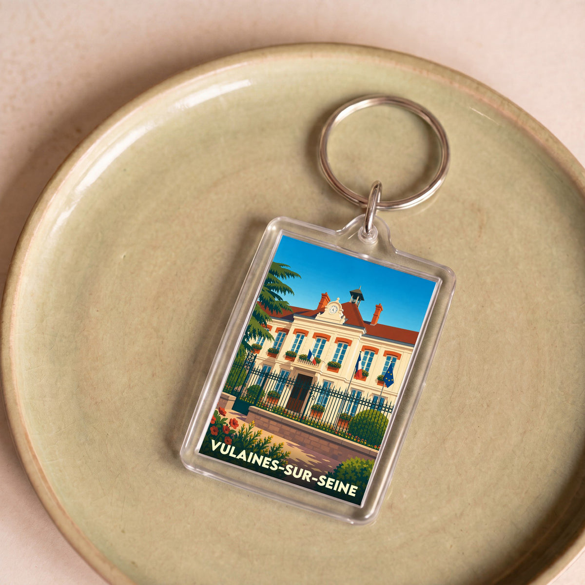 Porte-clés souvenir de la ville de Vulaines-sur-Seine avec une illustration stylisée de la mairie.