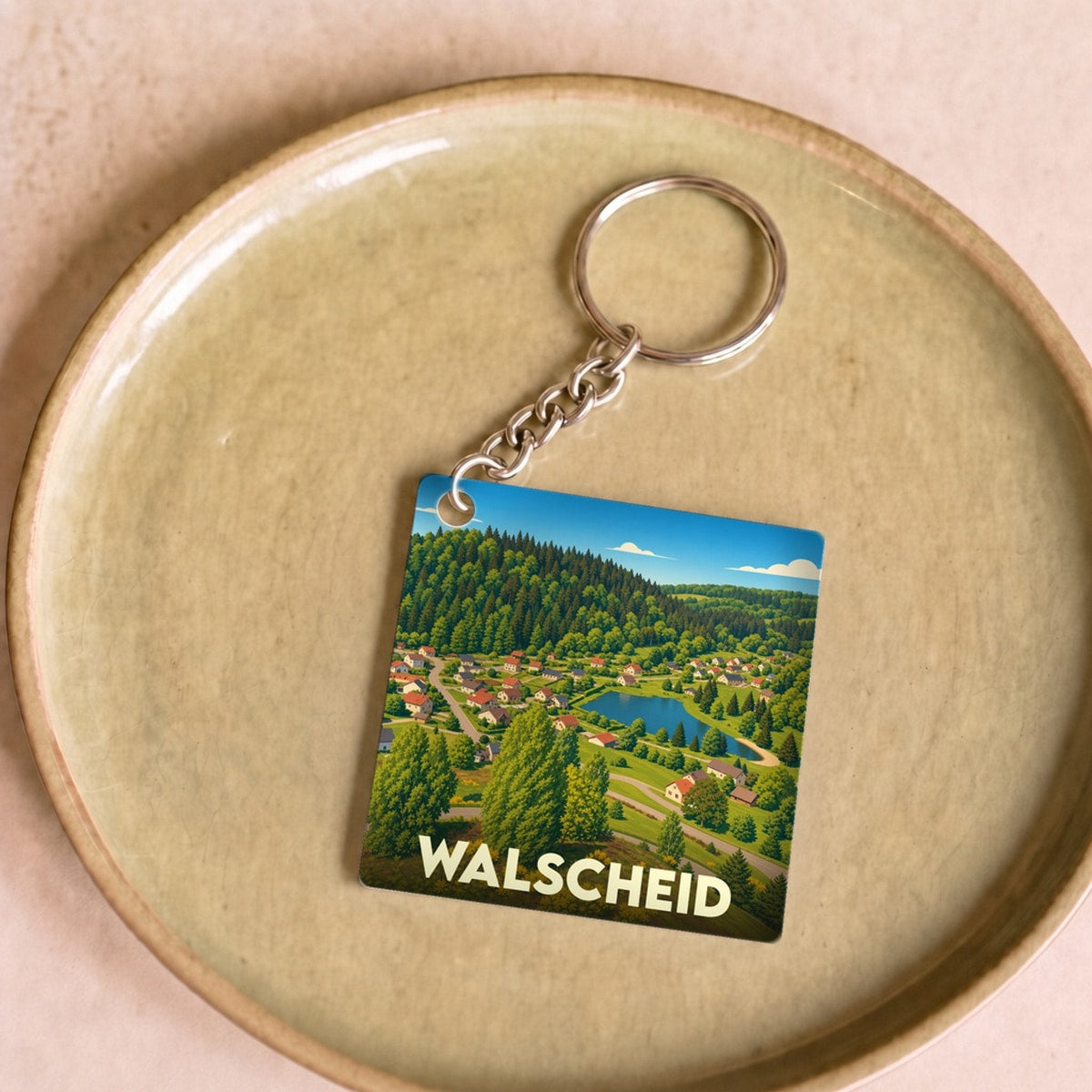 Porte-clés souvenir de la ville de Walscheid avec une illustration stylisée d'un paysage naturel.